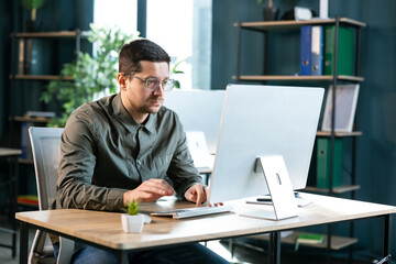 Side view of serious adult concentrated focused boss ceo businessman using typing on computer pc...