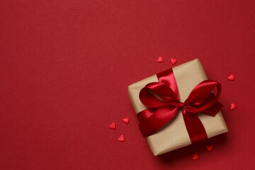 Beautiful gift box with hearts on color background