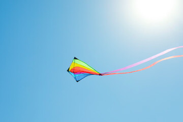 One colorful kite flying in blue sky