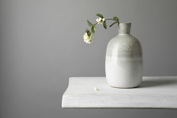 Stylish vase with snowberry branch on white table, space for text