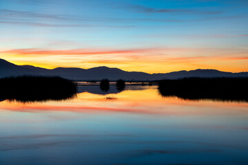 Fototapeta premium sunrise over the lake with orange and blue hues mixed in for a gorgeous image