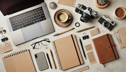A flat lay of office desk essentials, including a laptop, coffee, and notebooks, with neutral tones
