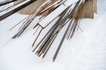 Beneath a thick, white layer of freshly fallen snow lies a heavy, hidden pile of rusty, aged metal...