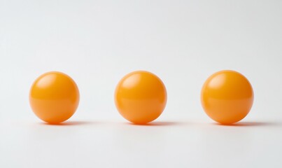 Three small orange balls on a white background. The balls are arranged in a row, with the middle one slightly larger than the other two.