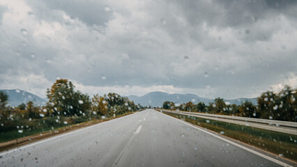 Fototapeta premium Rainy Highway View Capturing Speed and Reckless Driving on a Stormy Day