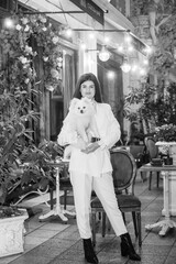 Obraz premium A girl holds a white fluffy dog ​​in her arms