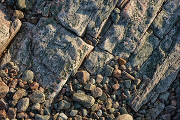 Sloping rock texture and pebbles below