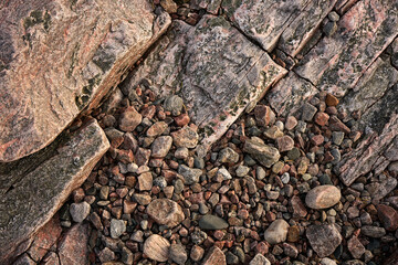 Sloping rock texture and pebbles below