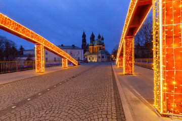 Obraz premium Illuminated bridge to the cathedral on Tumski Island at sunrise, Poznan, Poland