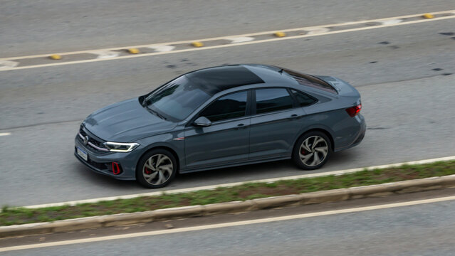 Grey Volkswagen Jetta GLI cruising city highway, High end sedan in movement, High resolution