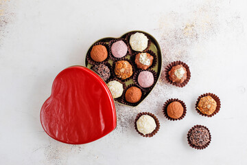 Homemade chocolate truffles with dark chocolate ganache covered with pink powder, waffle crumbles, gold flakes, coconut and nuts