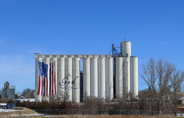 Grain elevator with American flag design against bright blue sky