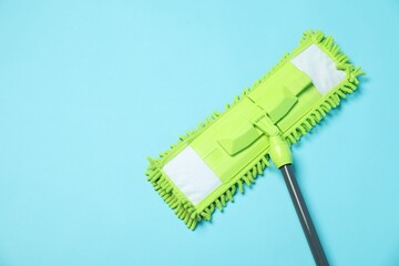 Microfiber mop on light blue background, top view. Space for text