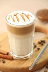 Tasty latte macchiato in glass on wooden table, closeup
