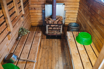 This exquisite and carefully constructed wooden sauna showcases beautifully vibrant green bowls along with a traditional wood stove, crafting an ideal atmosphere for relaxation and comfort