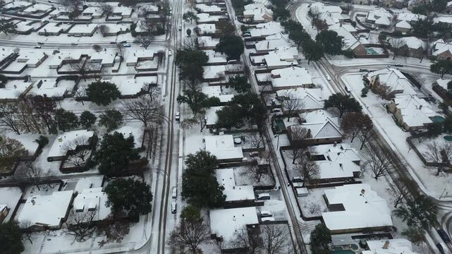 Suburban streets with residential houses in snow cover large backyard, back alley by heavy winter storm, Coppell, Texas, Dallas Fort Worth metroplex in severe weather, climate change, flyover