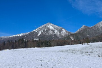 View of Tolsti vrh mountain and a snow covered field bellow in Gorenjska, Slovenia