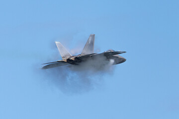 Very unusual close view of a F-22 Raptor at very high speed, with condensation cone...
