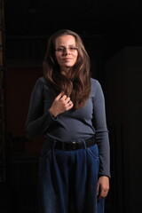 Beautiful young woman with long hair posing in dark room, closeup