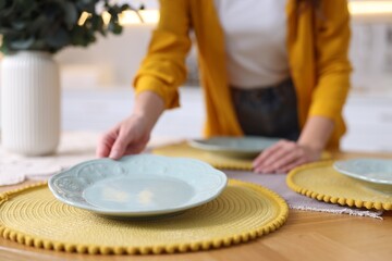 Woman setting table for dinner at home, closeup