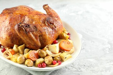 Delicious baked turkey, vegetables and cranberries on gray textured table, closeup. Space for text