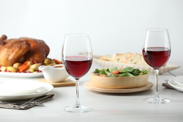 Red wine and delicious dinner served on light table