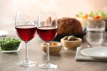 Red wine and delicious dinner served on wooden table