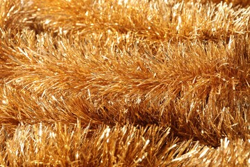 Shiny golden tinsel as background, closeup view