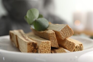 Palo santo sticks and eucalyptus leaves on blurred background, closeup