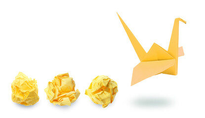 Yellow origami crane and crumpled paper balls on white background, banner design. Transformation or...