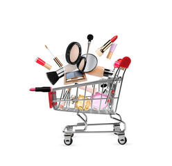 Different makeup products falling into small shopping cart on white background. Decorative cosmetics