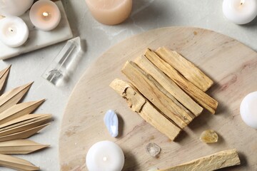 Palo santo sticks and gemstones on light table, flat lay