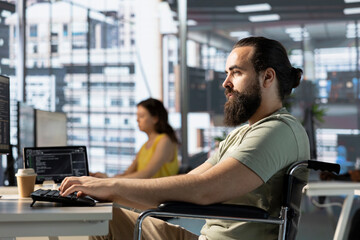Fototapeta premium Admin with disability in inclusive workspace utilizing cloud computing resources and platforms to train machine learning models. Person with paraplegia monitoring and maintaining company systems