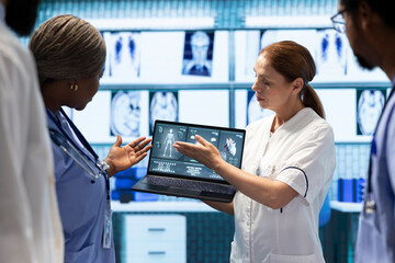 Obraz premium Healthcare professionals examine x ray electrocardiogram test results and patient care strategies in a medical office. Team of experts working to provide accurate diagnosis after ecg analytics.