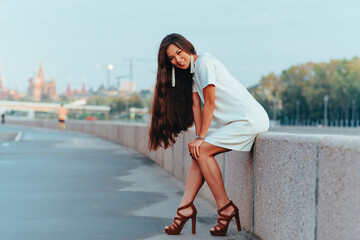 Young asian woman sitting on city stone quay in the morning