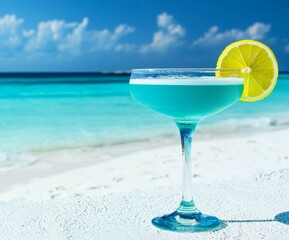Blue beach cocktail garnished with lemon, turquoise ocean backdrop.