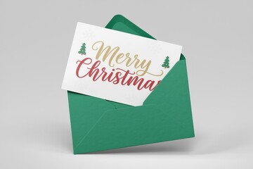 A green envelope holds a Christmas card with the words 'Merry Christmas' in festive script.