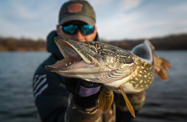 Fisherman and trophy Pike. Fishing background.