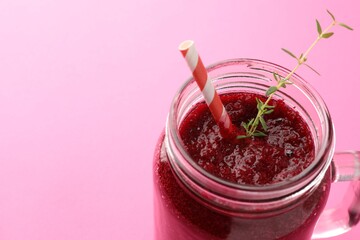 Fresh beetroot smoothie with thyme in mason jar on pink background, closeup. Space for text