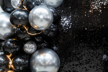 Generated imageLuxurious black and silver balloon arrangement with shimmering sequins and warm fairy lights. A perfect backdrop for elegant parties, New Year's celebrations, and glamorous events.