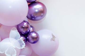 Romantic balloon composition featuring chrome purple and soft pink balloons, adorned with delicate white butterfly accents. The dreamy party setup creates an ethereal mood.