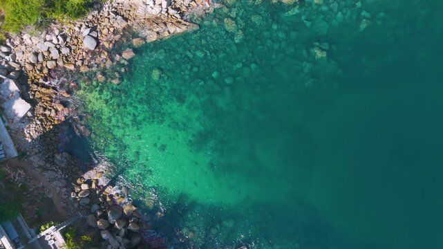 Aerial overhead view of a small bay with turquoise waters and rocky coastline in Acapulco, Mexico. This small tropical paradisiacal redoubt is the habitat of manta rays and colorful fish.