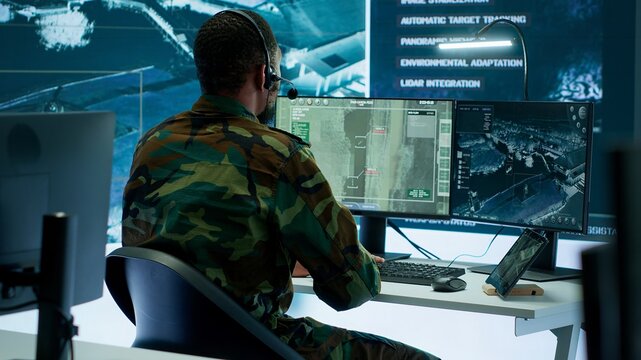 Soldiers in a modern command center analyze live data from cctv radar sources, satellite feeds and surveillance systems. Intelligence to support strategic planning and military operations. Camera A. - Powered by Adobe