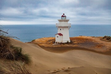 Coastal lighthouse on sand dunes overlooking the ocean. Tranquil scene. POUTO LIGHTHOUSE, POUTO,...
