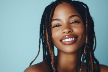 Smiling Black Woman with Dreadlocks in a Light Blue Studio Portrait