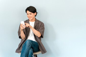 スマホ・スマートフォン・モバイルを使う若いアジア人男性
