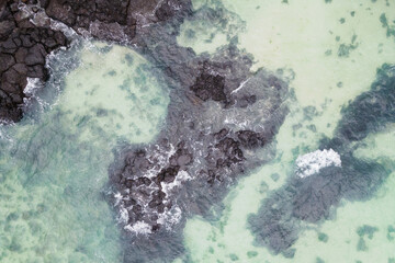 Sea and volcanic rocks close-up aerial view, natural background.