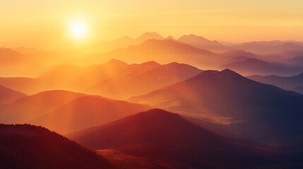 Fototapeta premium A serene sunrise over layered mountains, casting warm hues across the landscape.