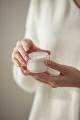 A woman holding cosmetics in a light-filled space
