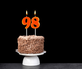 Birthday cake with number 98 candle - Anniversary card on a black background